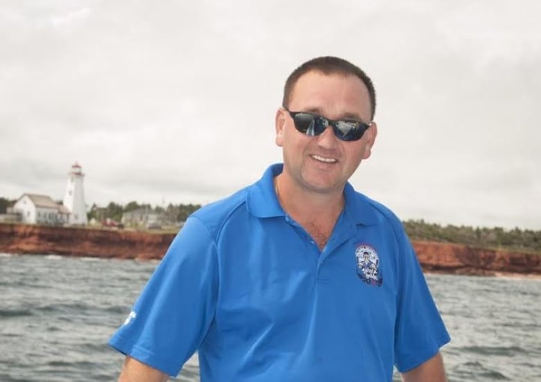 Jeff MacNeill on board a boat with a lighthouse in the background.