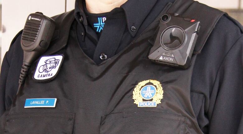 A person poses wearing a police body camera.