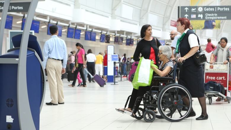 A wheelchair attendant assists a traveller at Toronto's Pearson airport. 