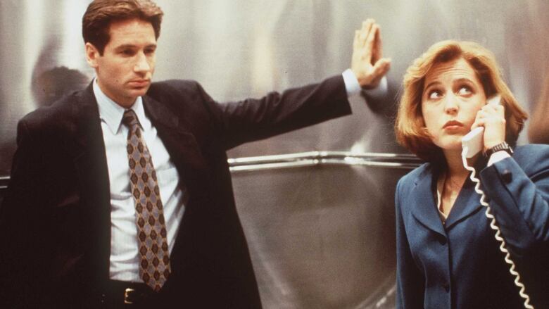 David Duchovny and Gillian Anderson appear in a 1996 promotional image for X-Files. The 90s show is deconstructed via podcast on The X-Files Files.