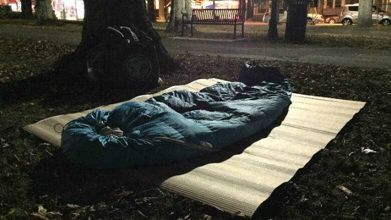 A sleeping bag on a bench outside