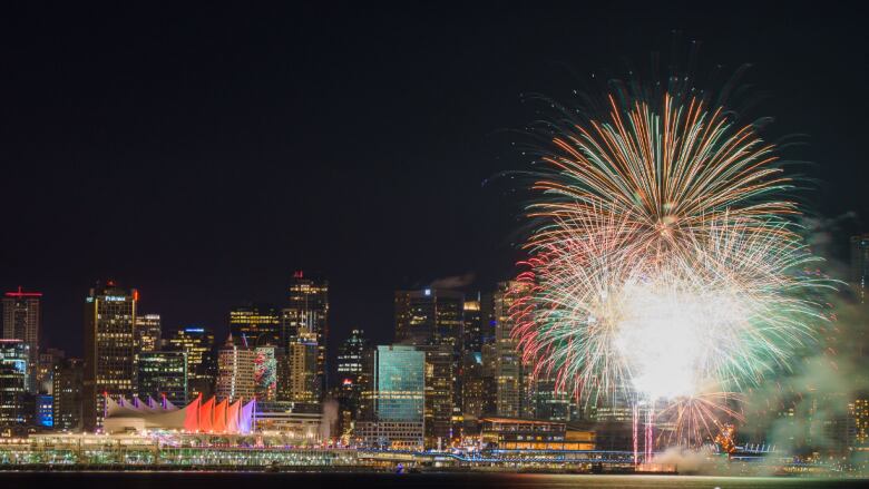 Fireworks explode over the Vancouver city skyline.