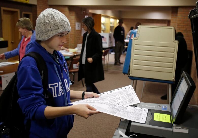 A voter feeds a ballot into a scanning machine during the 2012 presidential election.