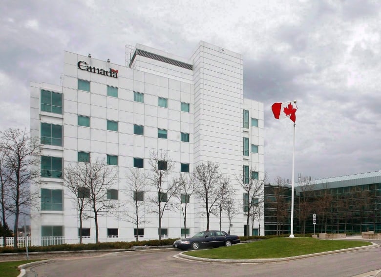 A building with a Canadian flag waving next to it.