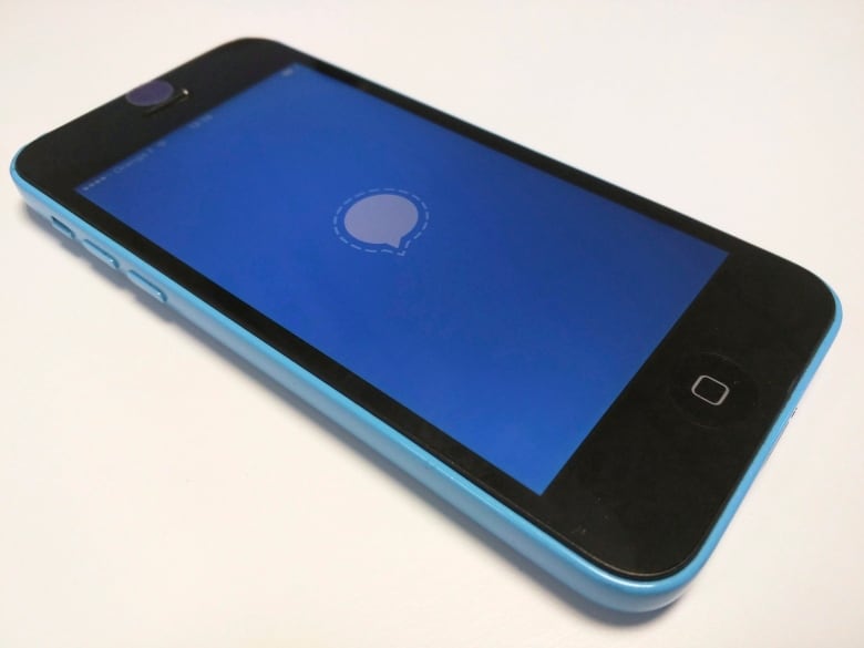 A photograph of a phone with a white chat bubble on a blue background.