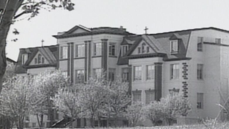 An old school building is pictured in a black-and-white-photo.