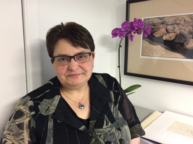 A woman sitting by a desk.