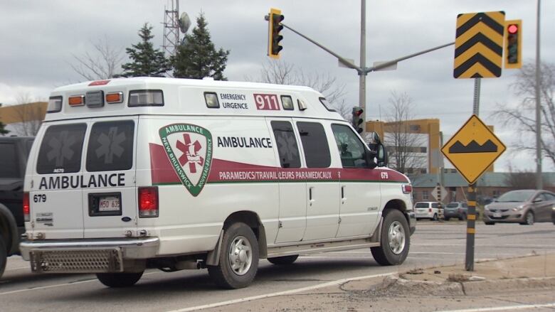 A white van with red stripes and lettering on a city street.