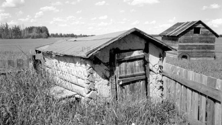 A black and white photo of an outbuilding 