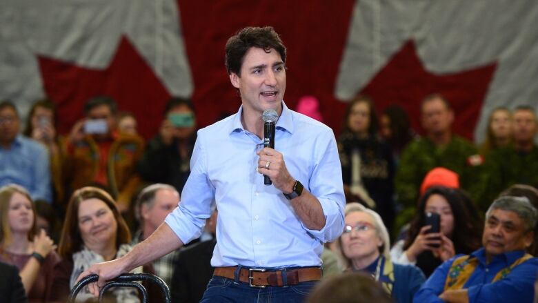 Canadian Prime Minister Justin Trudeau speaks into a microphone at a town hall meeting.