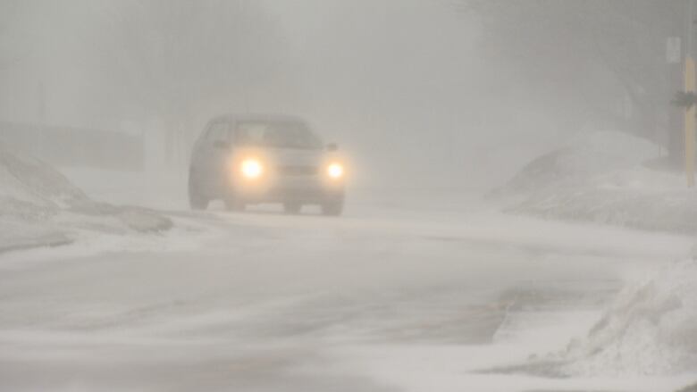 A car driving through a blizzard.