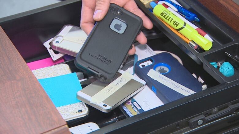 Hands  place cellphones  in  a drawer