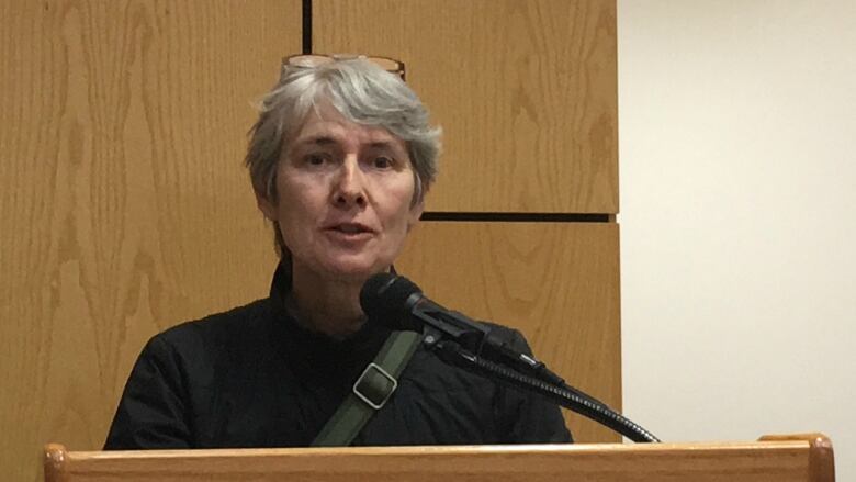 A woman speaks at a podium.