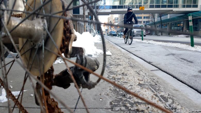 Close-up of a locked-up bike in downtown Calgary. Another biker is visible in the background.