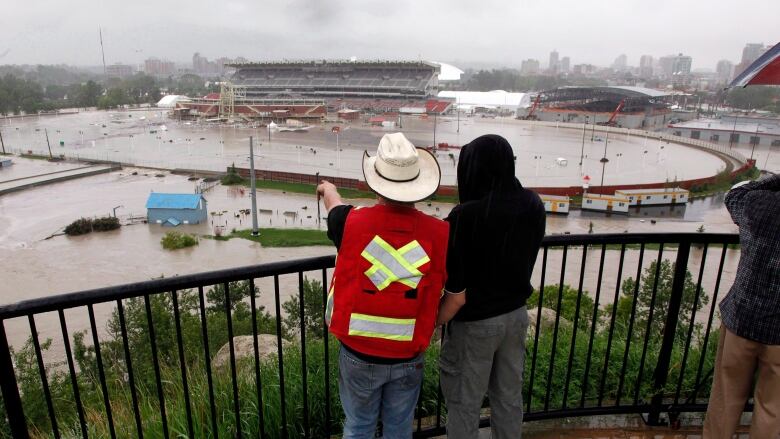 Two people look onto a flooded area.