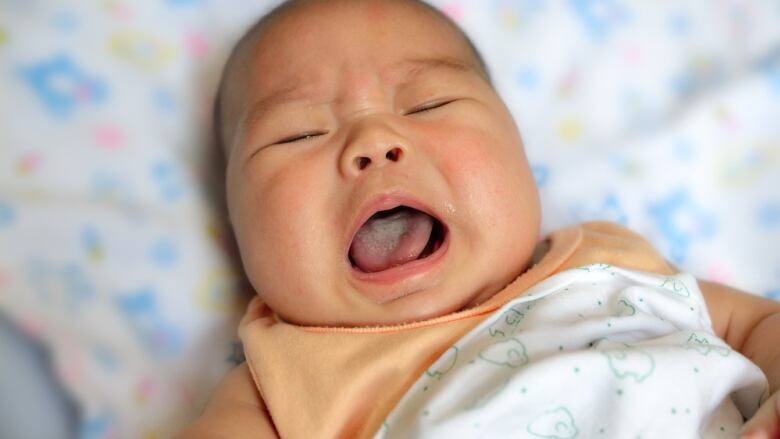 A baby is seen crying. 