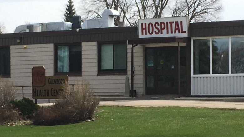 The front entrance of a long, one-story structure with a sign saying Hospital above the doors.