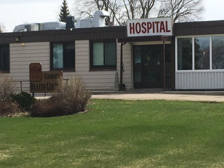 The front entrance of a long, one-story structure with a sign saying Hospital above the doors.