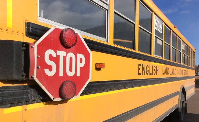 View of the side of a P.E.I. school bus, with stop sign prominent.