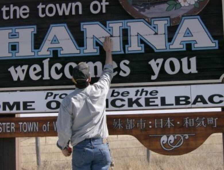 A man standing in front of a sign that says