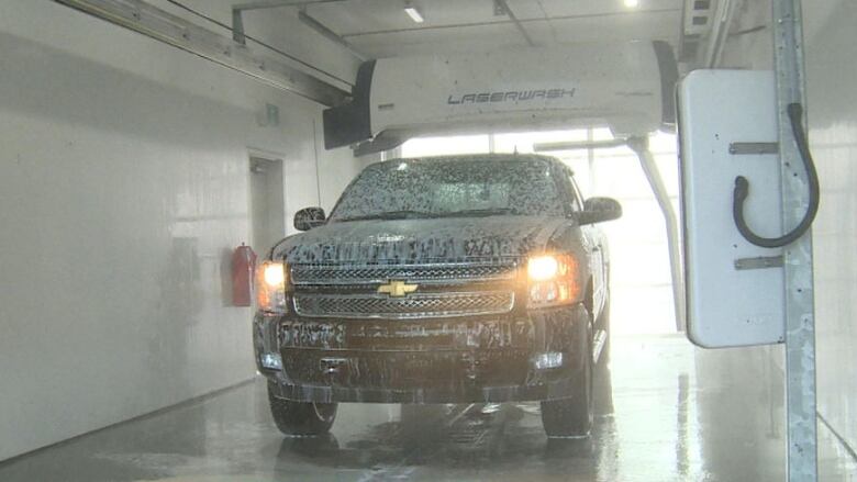 A black truck goes through a car wash.