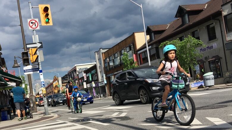 A young family rides west on the Bloor Street bike lane in Toronto.