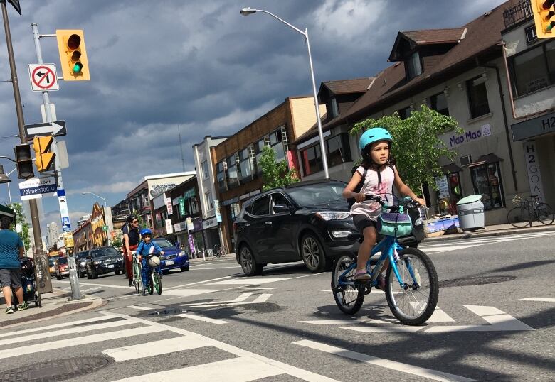 A young family rides west on the Bloor Street bike lane in Toronto.