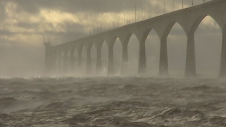 Waves crashing against bridge.