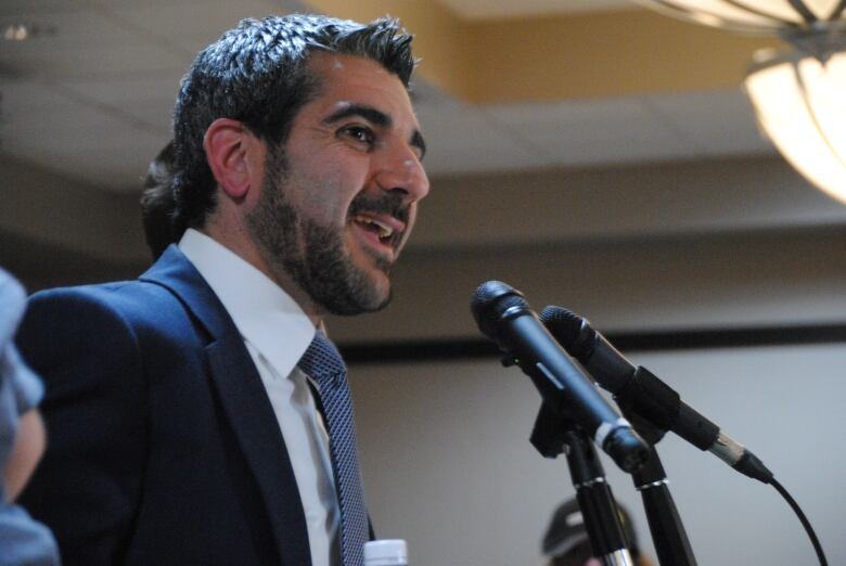 A man speaking at a microphone.