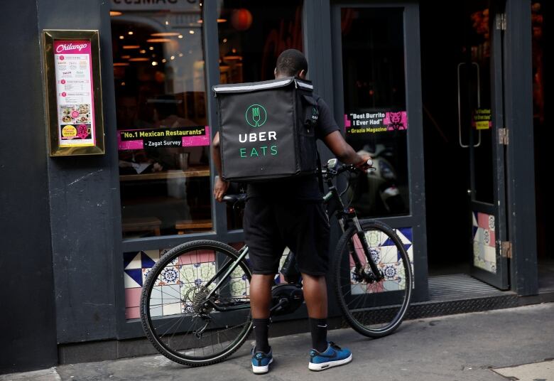 An UberEATS food delivery courier prepares his bike in London, Britain.