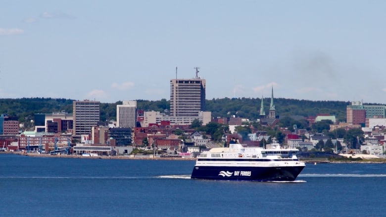 A feery is seen with the backdrop of Saint John in the background.