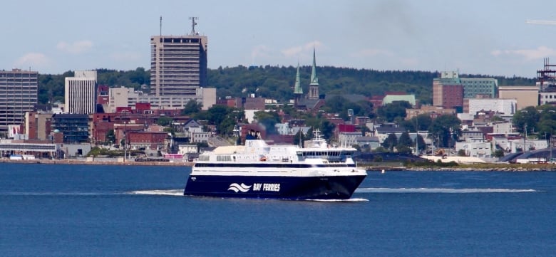 A feery is seen with the backdrop of Saint John in the background.