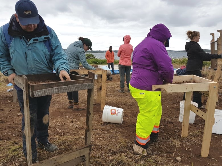 Archaeology students work to save 19th-century graves from coastal erosion at the fortress of Louisbourg in 2017.