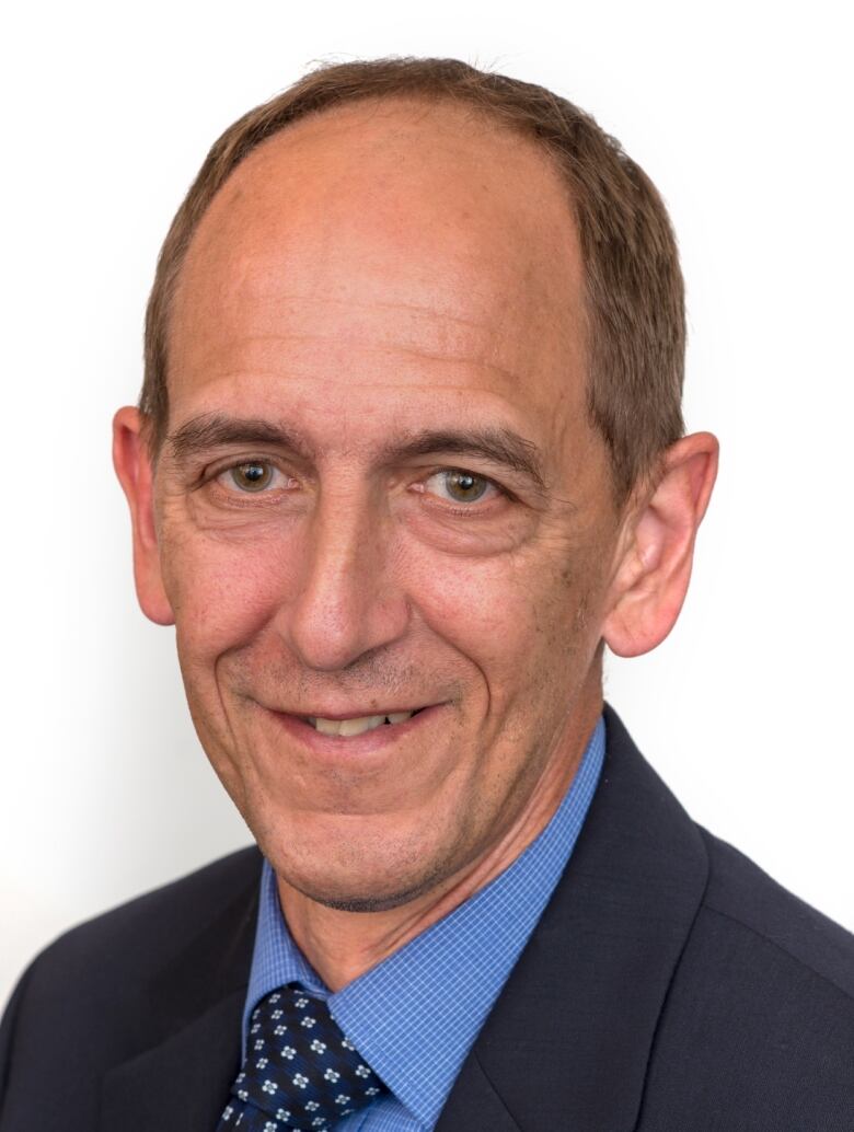 Headshot of a man with a white background.