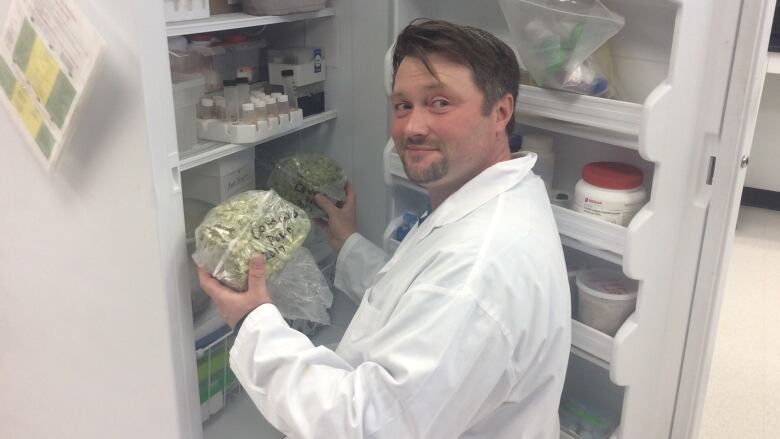 A scientist holds plants taken from a freezer