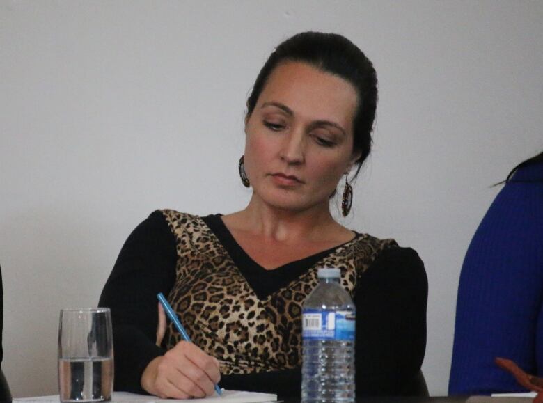 Naiomi Metallic is seen seated at a conference.