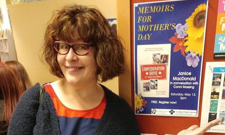 Woman in glasses poses and smiles for a photo