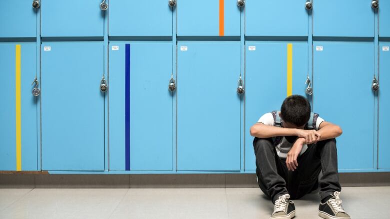 Sad student at locker.