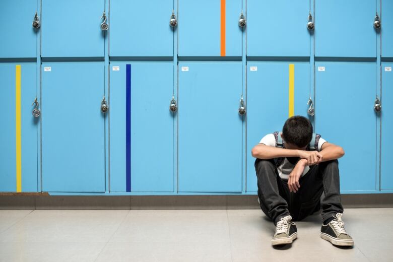 Sad student at locker.