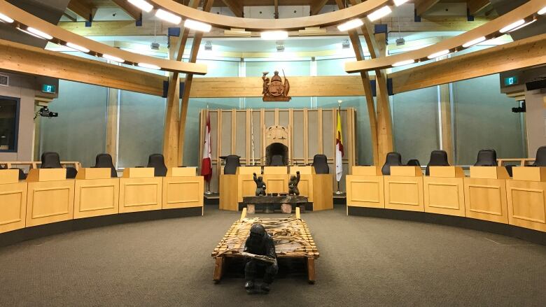 Inside an empty legislative assembly room.