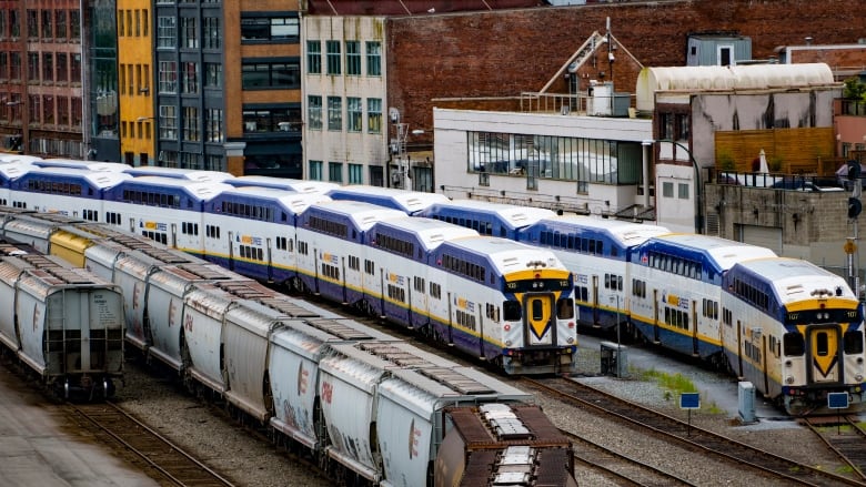 Commuter rail cars sit on tracks in a downtown Vancouver marshalling yard.