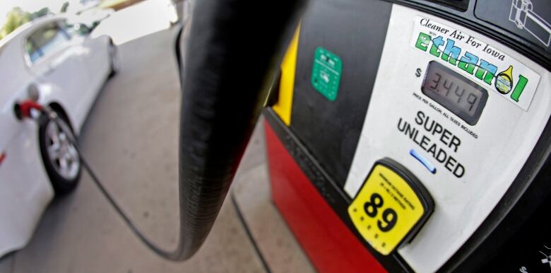 A gasoline hose runs from a pump tank with a label saying 