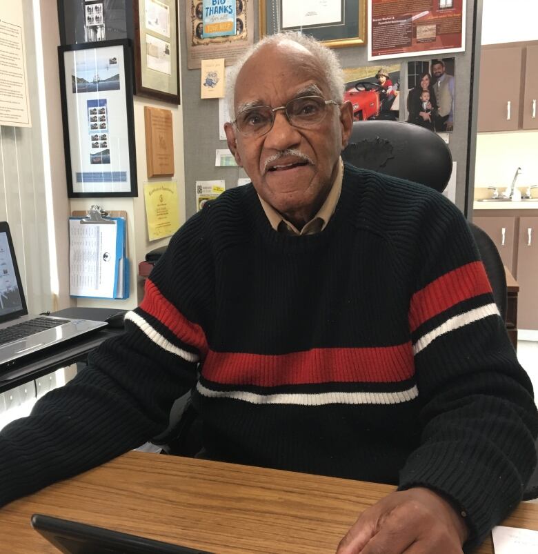 Man sitting at desk looking at camera.