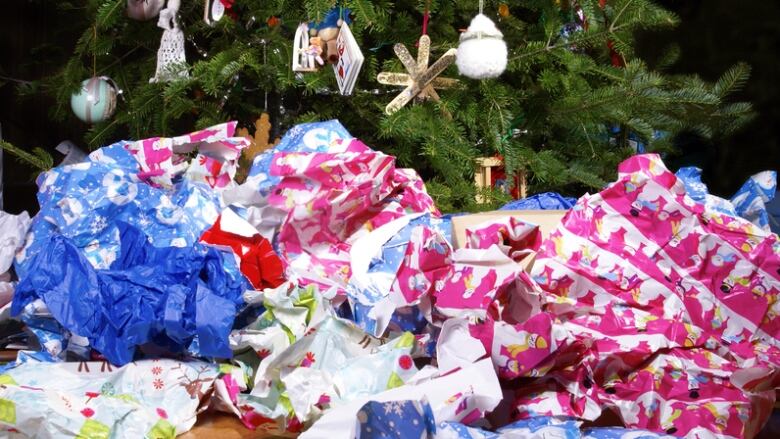 A pile of bundled up Christmas wrapping paper. 