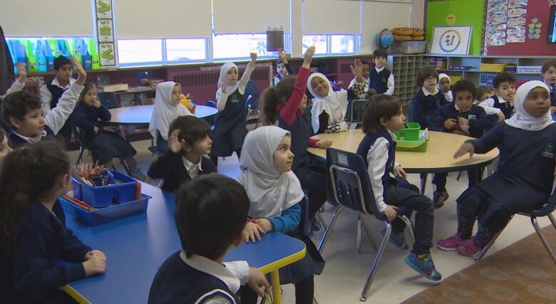 Kindergarten students at Al Mustafa School volunteer to help with a lesson. 