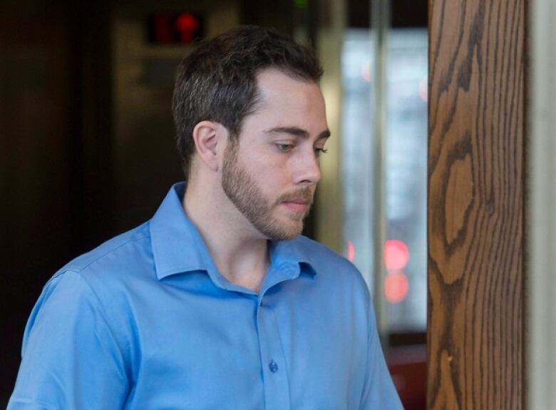 A bearded man in a blue shirt is seen in profile