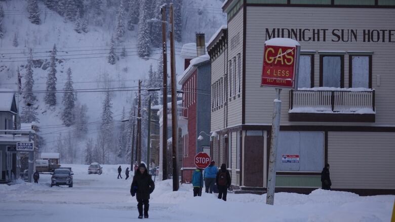 People walking through the snow on the street in Dawson on a cold winters day. 