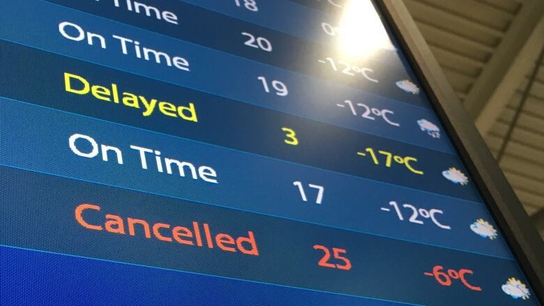 A departures board at Ottawa's international airport shows a delayed and a cancelled flight. 