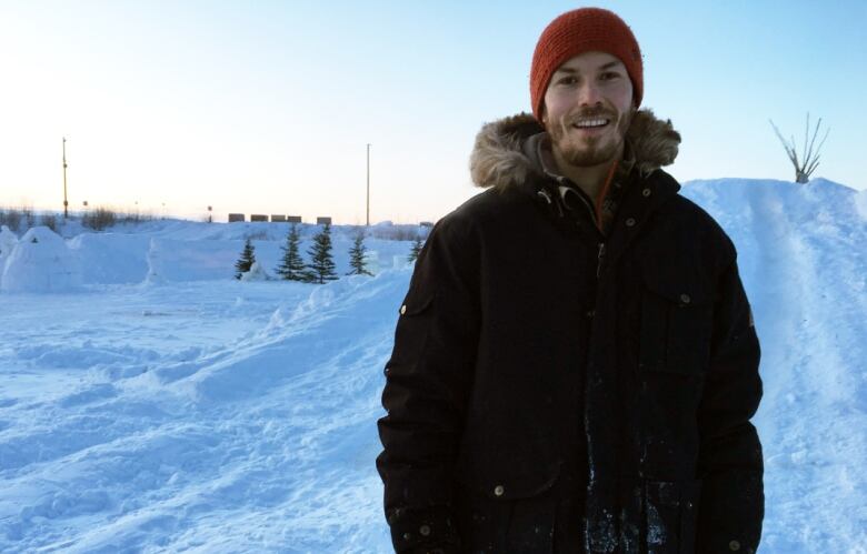 A man stands outside in the snow.