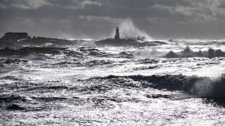 A lighthouse is bashed by waves.